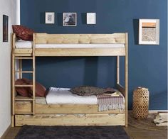 a wooden bunk bed sitting next to a blue wall