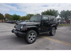 a black jeep parked in a parking lot