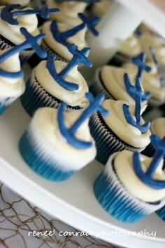 cupcakes with white frosting and blue decorations