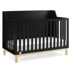 a black crib with white sheets on it