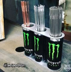 three monster energy drink cans stacked on top of each other with straws in them