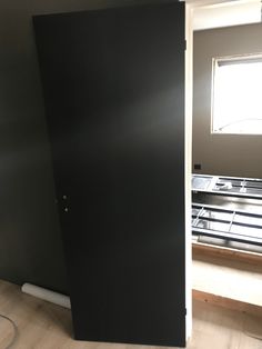 an empty room with a black door in it