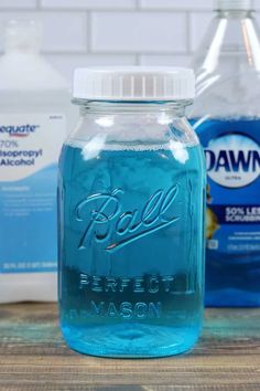 a blue mason jar with ball perfect mason on the table next to bottles of water