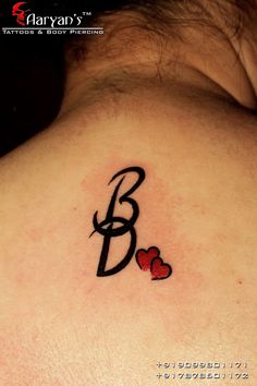 a woman's upper back tattoo with the letter b and two hearts