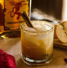 an apple cider cocktail is garnished with cinnamon