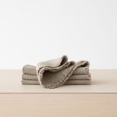 three folded towels sitting on top of a wooden table