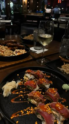 plates of sushi and wine on a table in a restaurant