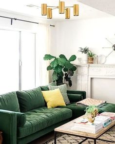 a living room filled with green couches and a fire place next to a fireplace