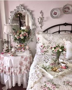 a bedroom with pink walls and white bedding has flowers on the bedspread