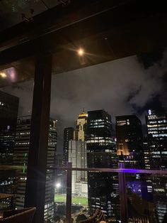 the city lights shine brightly at night in this view from a rooftop restaurant's balcony