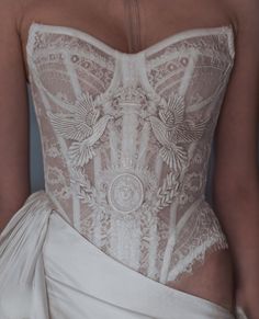 the back of a woman's wedding dress with an intricate lace design on it