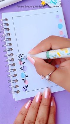 a woman's hands holding a pen and writing on a notepad