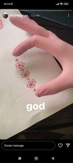 a hand that is on top of a piece of paper with the word god written in it