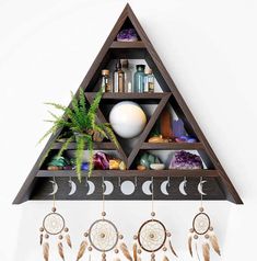 a triangle shelf with dream catchers hanging from it