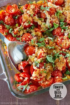 a bowl filled with lots of food next to a metal serving spoon on top of a table