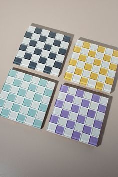 four different colored tiles sitting next to each other on top of a white countertop