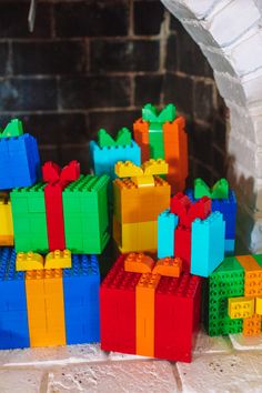 colorful legos are stacked on top of each other in front of a brick fireplace