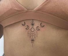 a woman's stomach with three phases on her side and the moon behind it