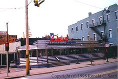 an old photo of a street corner with buildings in the background and a traffic light