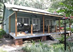 a small blue house sitting in the middle of a forest