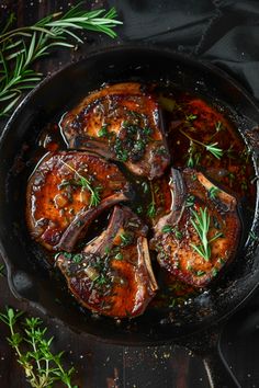 pork chops in a skillet with fresh herbs