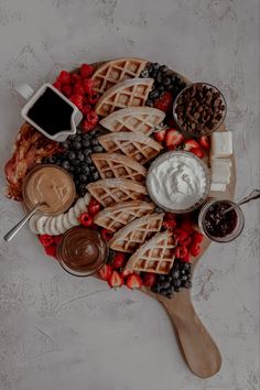 a platter with waffles, fruit, and other toppings on it