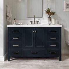 a white toilet sitting next to a bathroom sink under a mirror on top of a wooden cabinet