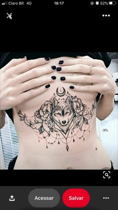 a woman's stomach with a wolf tattoo on the side and her hands covering her face