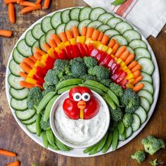 a platter with vegetables, veggies and a face painted in the shape of a turkey