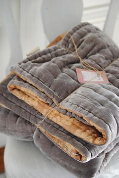 a stack of blankets sitting on top of a white chair