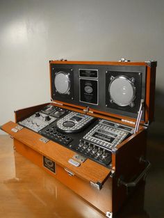 an old fashioned radio and sound equipment in a case on top of a wooden table