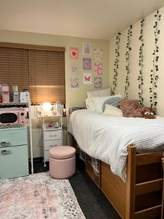 a bed room with a neatly made bed next to a dresser and stove top oven