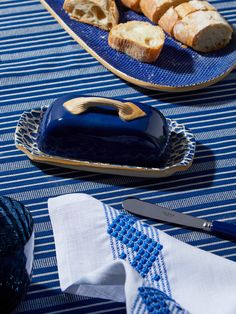 bread on a blue plate with a knife next to it and some other food items