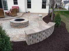 a brick patio with a fire pit in the middle