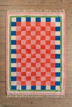 an orange and blue rug on a wooden floor