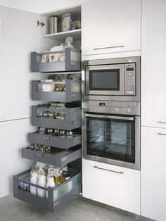 a kitchen with an oven, microwave and shelves in the wall next to each other