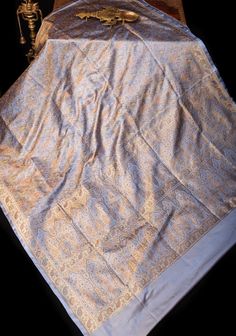 an old table cloth is laying on top of a wooden table with a skeleton in the background