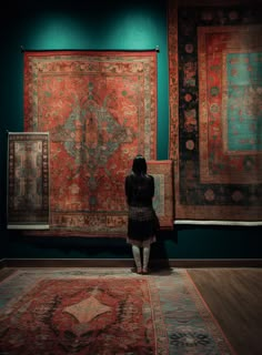 a woman looking at rugs in an art gallery