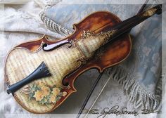 an old violin laying on top of a bed