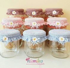 several jars with crocheted doily and flowers in them