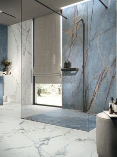 a bathroom with marble walls and flooring next to a walk - in shower stall