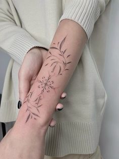 a woman's arm with a flower tattoo on it