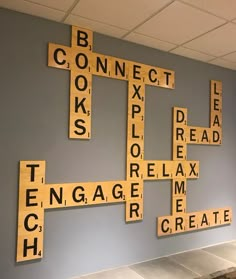 several scrabble tiles are arranged in the shape of letters on a gray wall