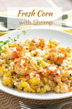 shrimp, corn and feta salad on a white plate with silver utensils