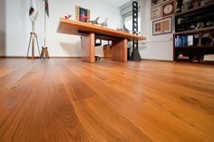 an empty room with wooden floors and a table on the floor in front of it