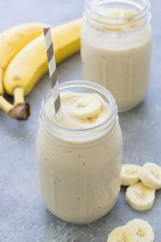 a banana and peanut butter smoothie in a mason jar with two bananas on the side