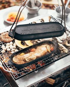 an outdoor grill with food cooking on it