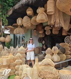 a woman standing in front of some baskets