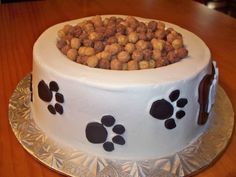 a cake decorated with dog paw prints on top of a wooden table and silver platter