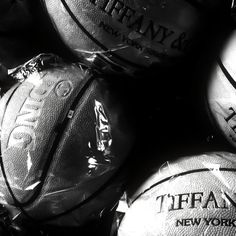 black and white photograph of basketballs wrapped in plastic